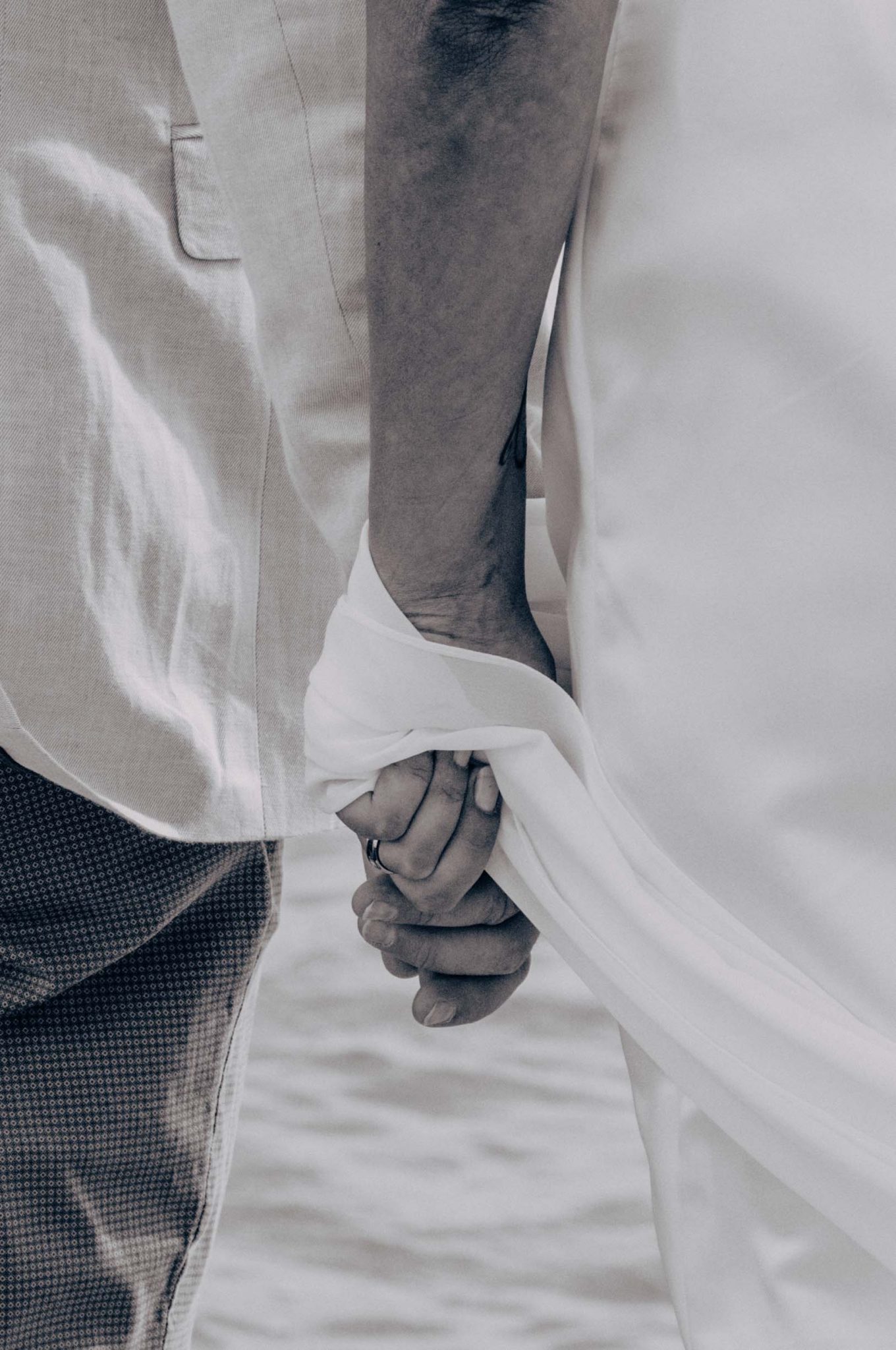 Photographie de mariage, mains qui se tiennent, mer, photographie en noir et blanc